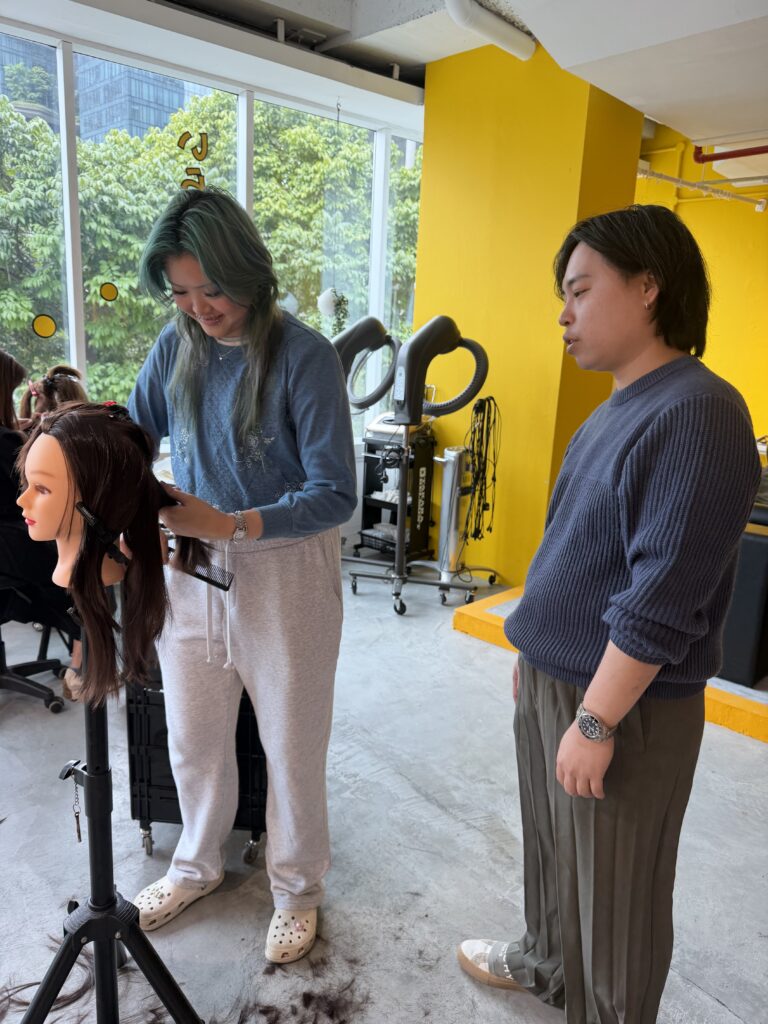 Training Japanese Techniques in Singapore: Andy Coaching ITE Intern at Colors Hair Salon 1 Training Japanese hair techniques at Colors Japanese Hair Salon Singapore near Clarke Quay MRT — Senior Stylist Andy coaching ITE intern for consistent haircut, hair color, highlights and grey blending results