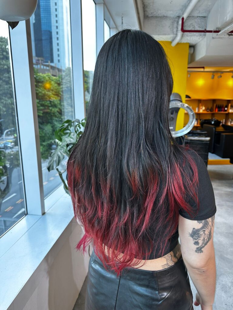 Long layered haircut with ends bleach red color at Colors Japanese Hair Salon Singapore, red tips visible with curls or hand-dry styling