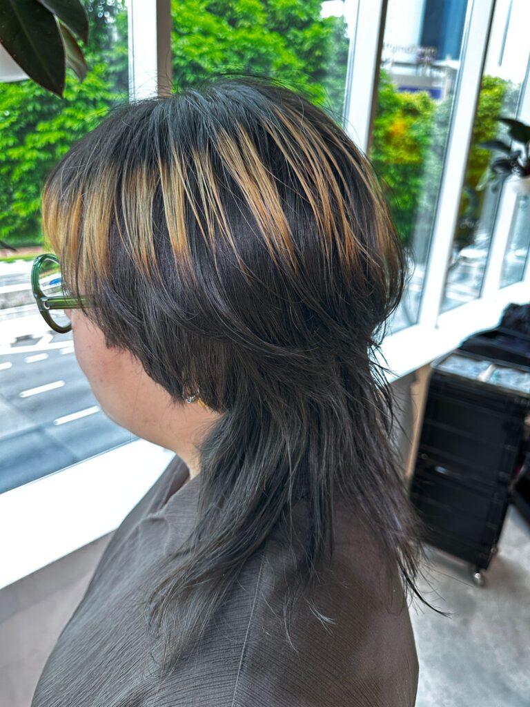 Black and blonde ring color design on high layer wolf haircut at Japanese hair salon Singapore, surface mid section bleach detail