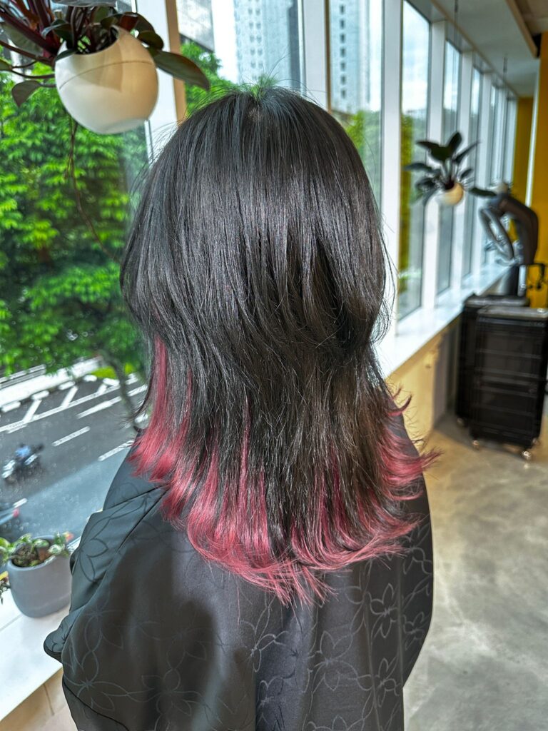 Medium wolf haircut with inner bleach and vivid red color, layered design at Japanese Hair Salon Singapore for dimensional movement.