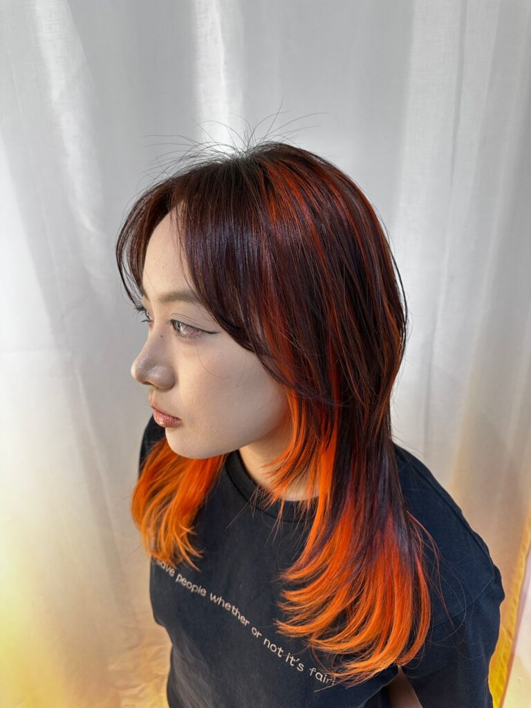 Highlight and inner vivid orange design color with layered medium wolf cut at Japanese Hair Salon Singapore near Clarke Quay and Chinatown.