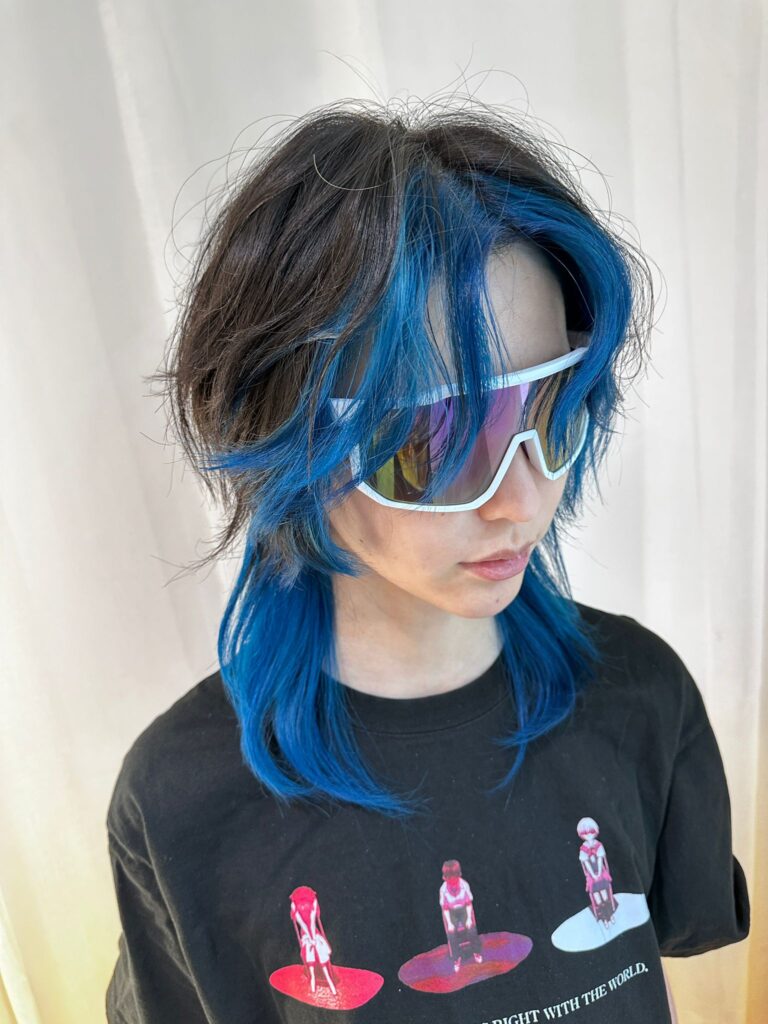 Face framing blue highlights on medium layered hair at Colors Japanese Hair Salon Singapore, bold contrast design color near Clarke Quay.