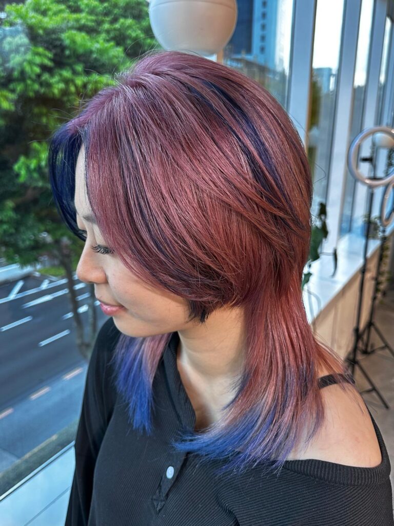 Full bleach design color with pink ash and blue ash accents on face frame and nape, layered wolf cut at Japanese hair salon Singapore