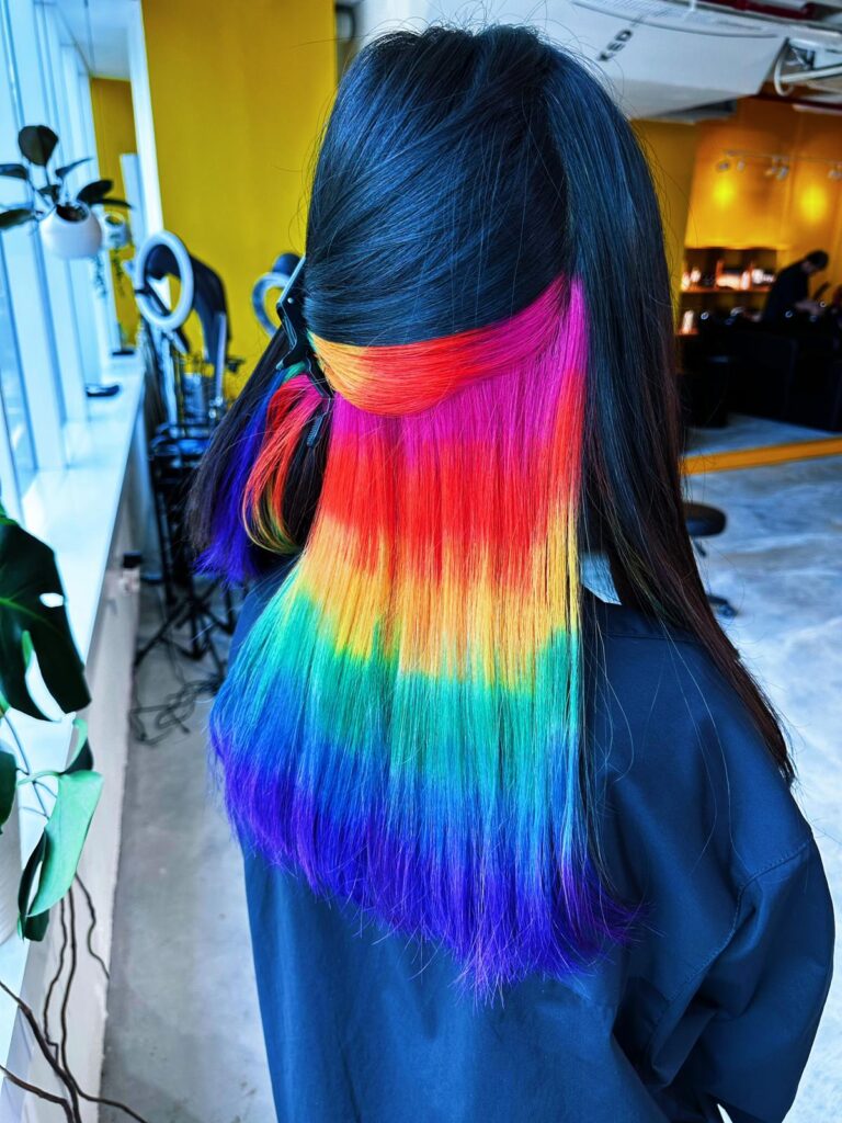 Inner rainbow color on long straight hair with double bleach, vivid multi-tone design hidden inside at Colors Japanese Hair Salon Singapore