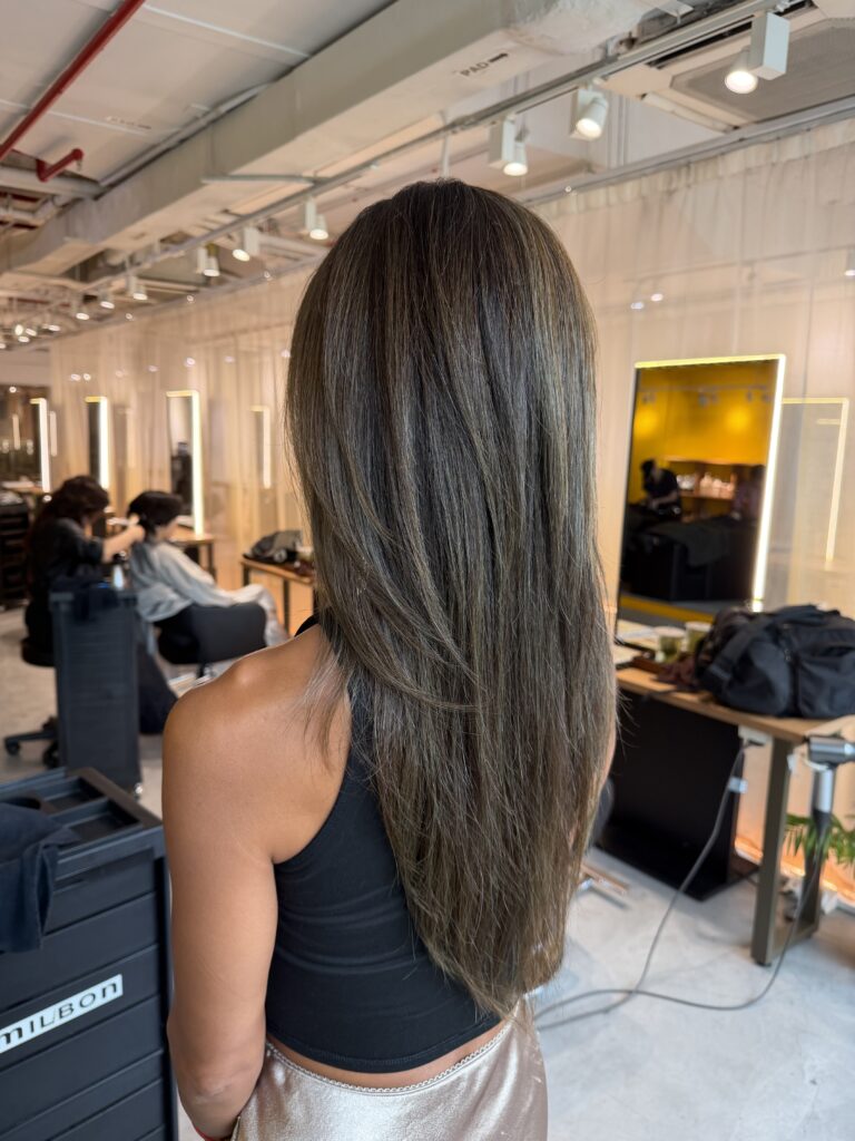 Long high layer haircut with olive ash grey coverage at Japanese Hair Salon Singapore. Low-damage Plex color keeps hair bright while naturally blending grey hair with healthy shine.