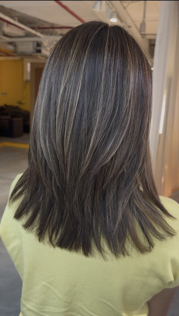 Medium layered haircut with grey blending highlights in soft gold beige at a Japanese Hair Salon Singapore. Plex Color helps minimize damage while blending grey hair naturally with a dimensional, healthy-looking finish.
