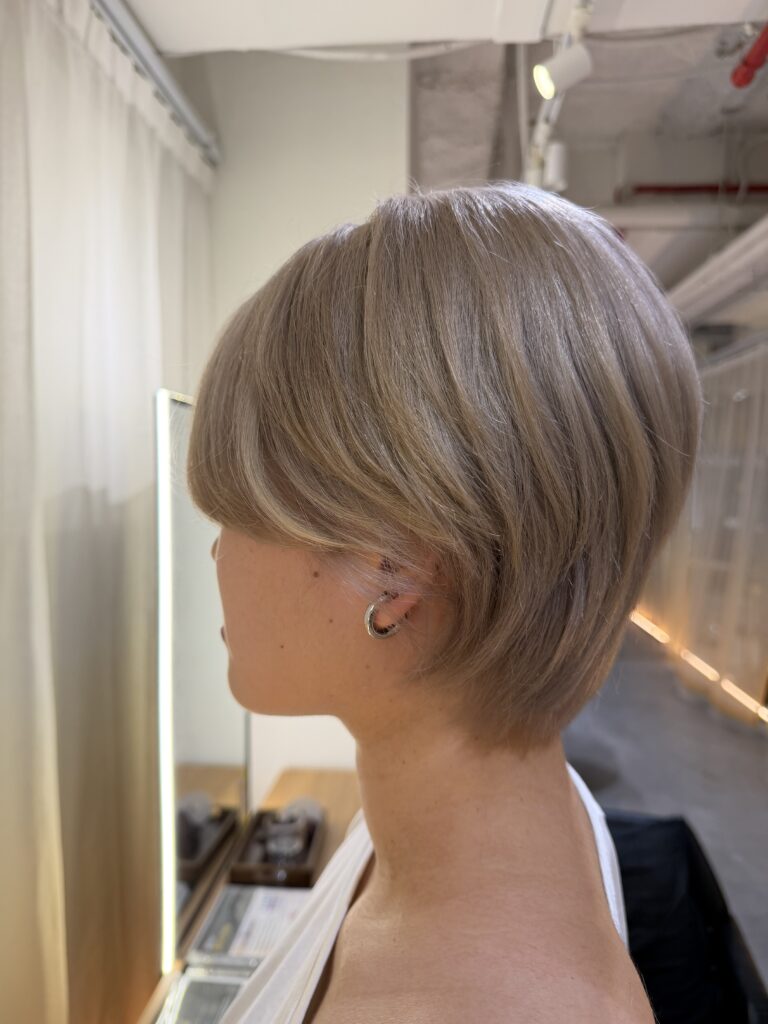 White Beige Short Layer Hair with Plex Bleach | Singapore 1 White beige short layered hair with Plex bleach at a Japanese Hair Salon Singapore, featuring a soft neckline and cheek-length face-framing bangs.