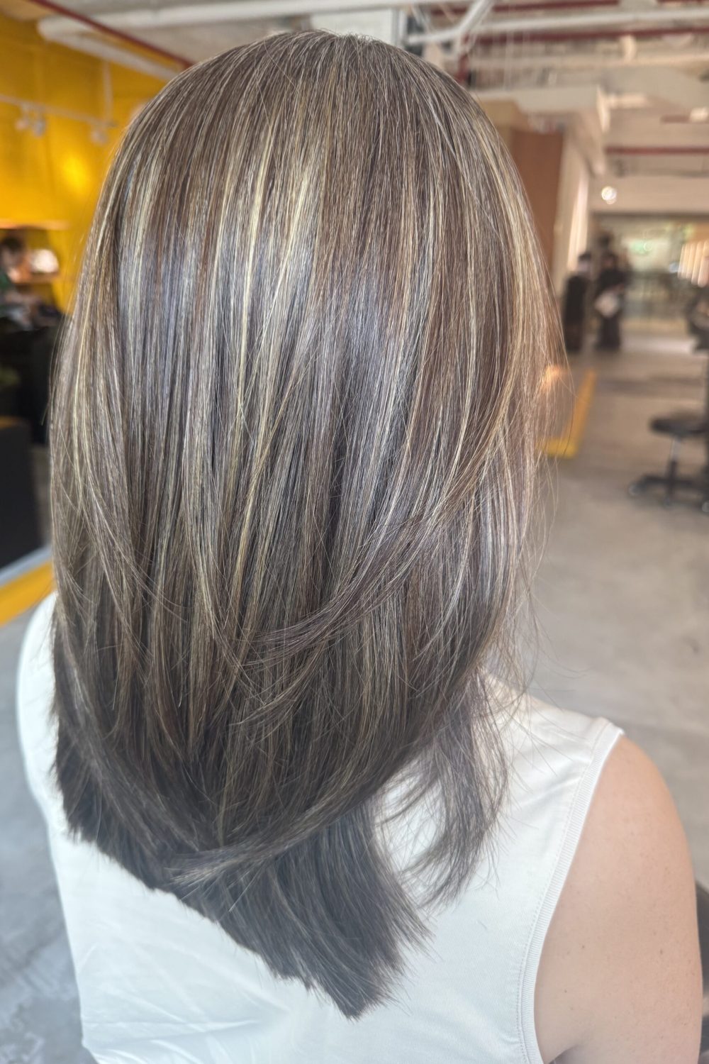 Medium low-layer haircut with beige ash grey blending highlights, smooth straight texture and natural grey blending at a Japanese hair salon in Singapore.