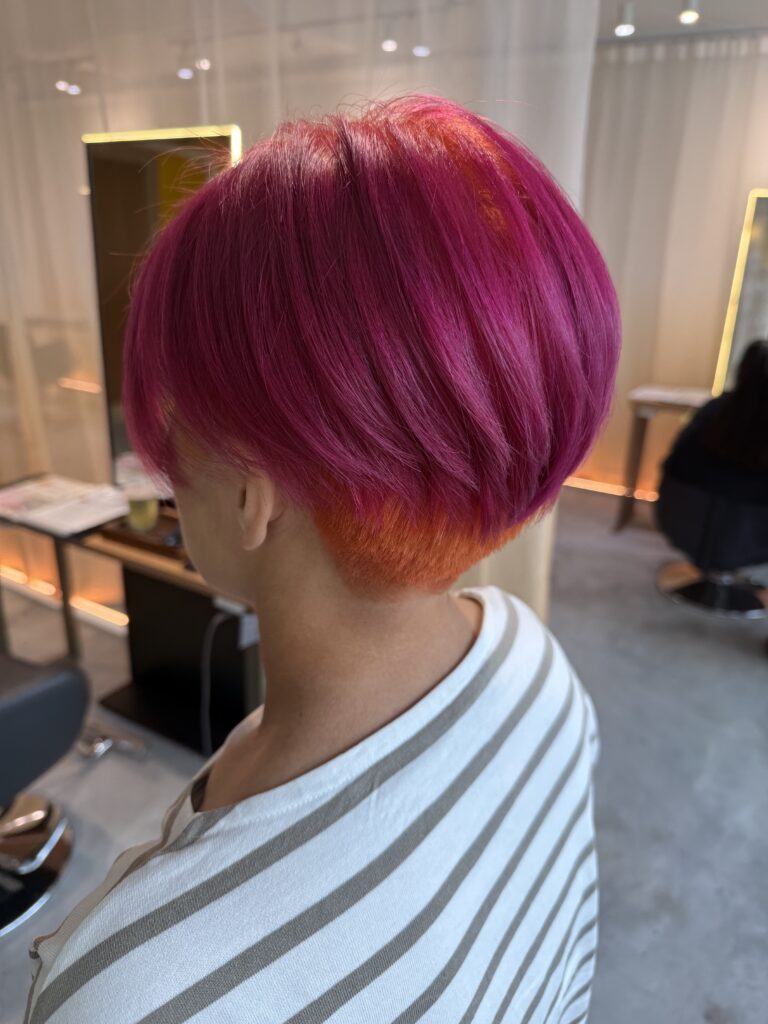 Crazy color short hairstyle with care bleach at Colors Japanese Hair Salon Singapore, featuring vivid pink ends and orange roots with low-damage bleaching near Clarke Quay.