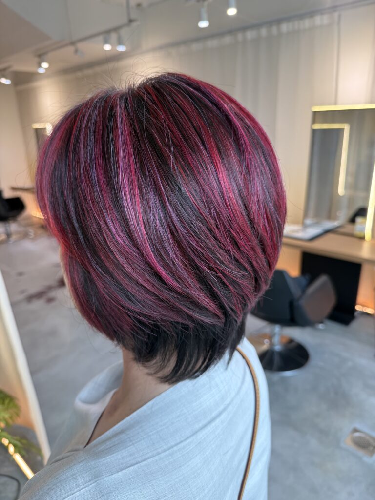 Short hairstyle with red highlights for grey hair at Colors Japanese Hair Salon Singapore, creating contrast and brightness without darkening the base.