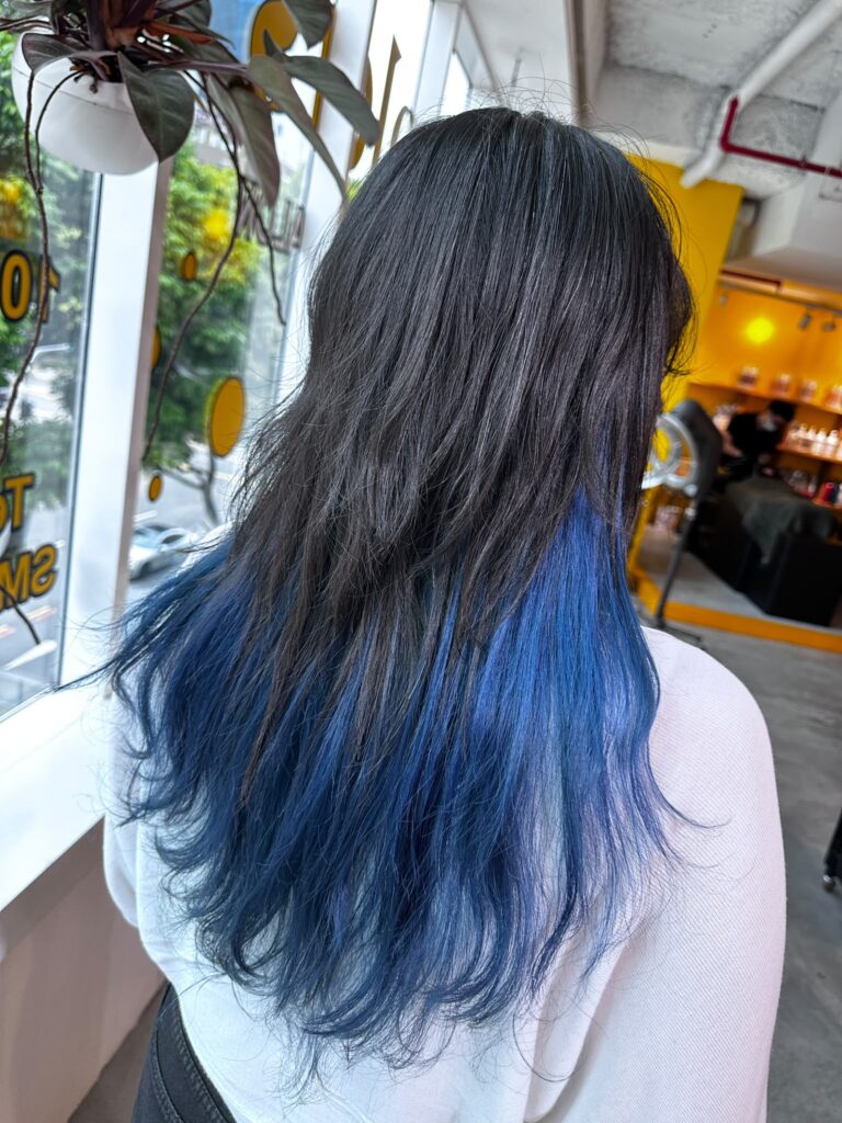 Blue inner hair color with low-damage Plex bleach by Stylist Issey at Colors Japanese Hair Salon Singapore, featuring a hidden fashion color with a natural outer layer.
