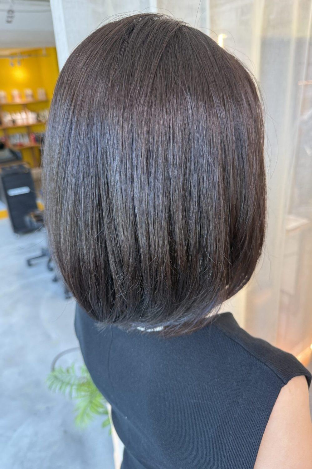 Dark brown bob haircut with grey coverage color and smooth heavy silhouette at Colors Japanese Hair Salon Singapore