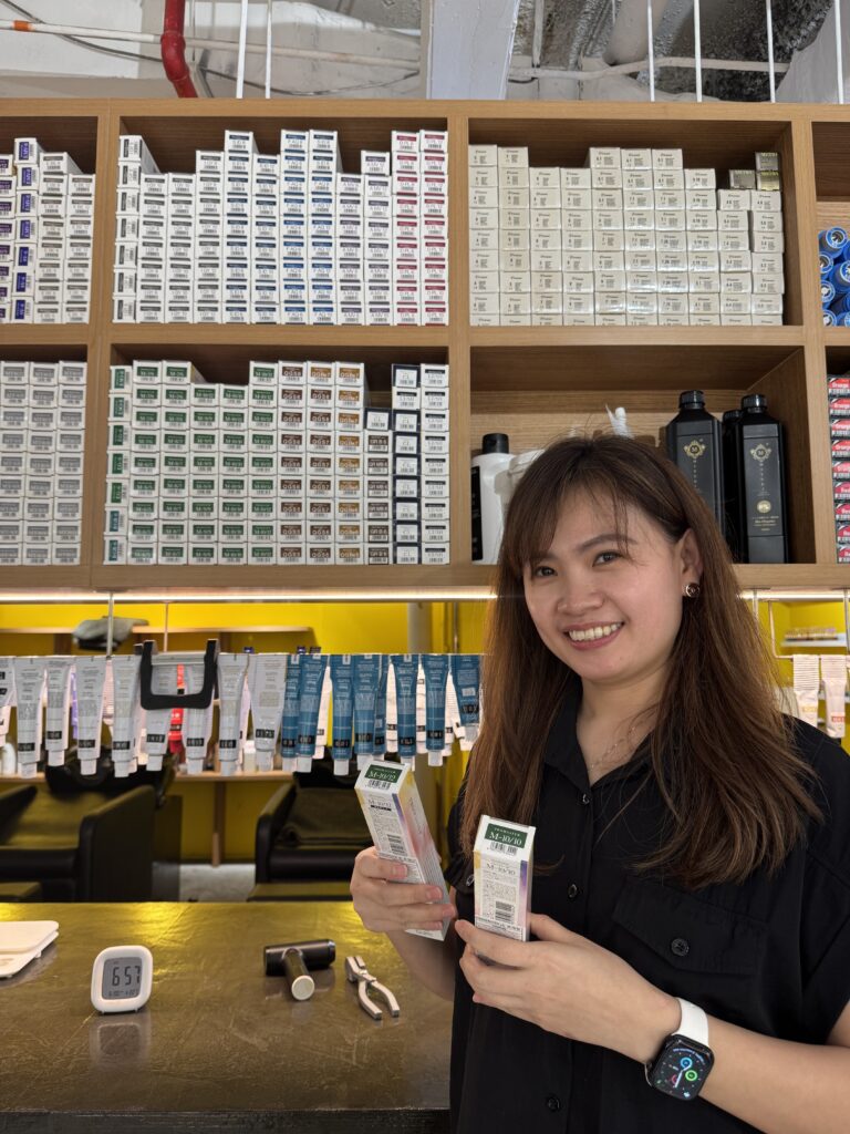 【Hoyu Japanese Color for Sensitive Scalps – Colors Japanese Hair Salon Singapore】 1 Stylist Sylvia presenting Hoyu Japanese sensitive-scalp color at Colors Japanese Hair Salon Singapore, using gentle low-stimulus formulas.