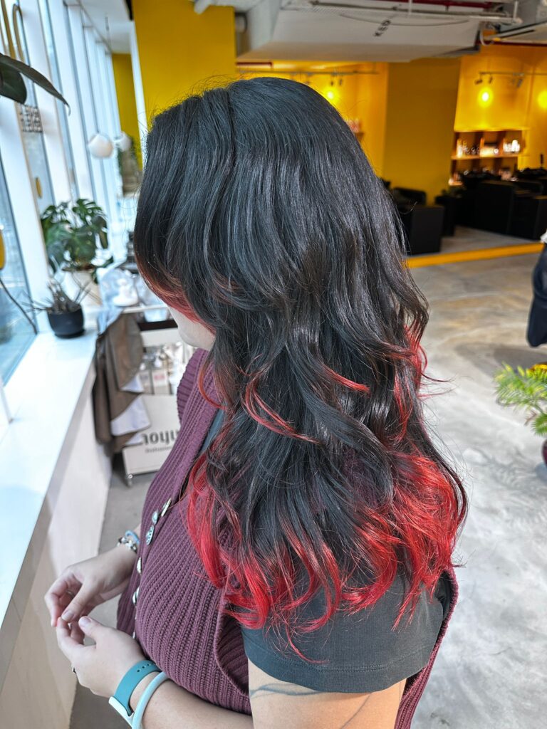 Long wavy hair with vibrant red ends design color, created using Japanese bleaching techniques at Colors Japanese Hair Salon Singapore.