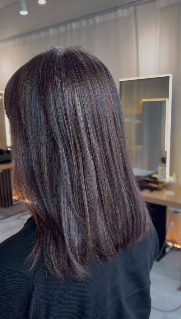 Natural grey blending on medium-length hair transitioning from a previous red-based color to a soft neutral tone, low-maintenance regrowth, glossy finish at Japanese hair salon in Singapore near Clarke Quay MRT and Chinatown (Colorist Ura, Stylist Carmen).
