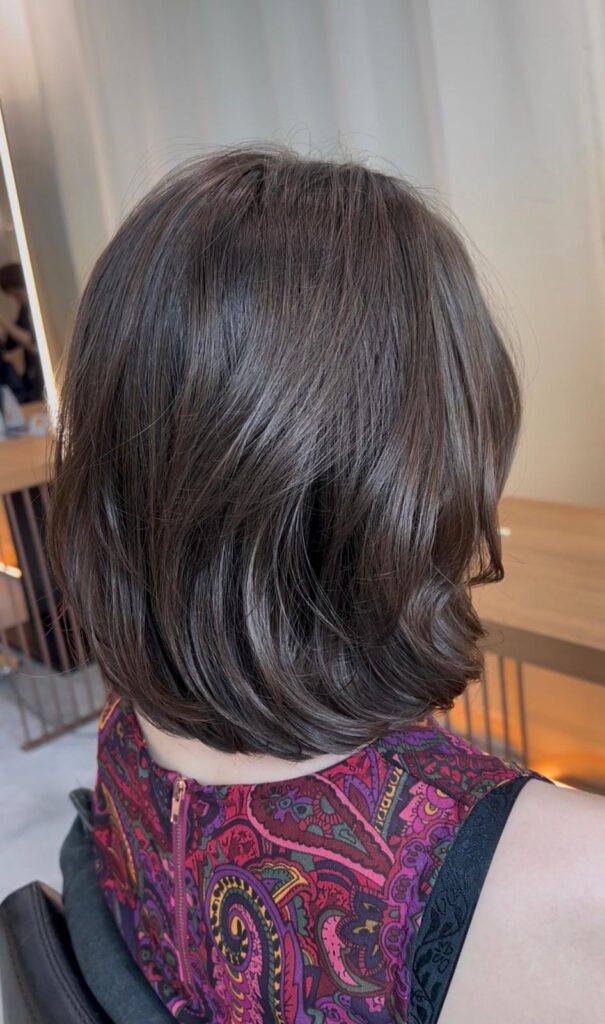 Medium Wavy Haircut Ash Brown Grey Coverage | Japanese Hair Salon Singapore 1 Natural perm and brown hair color with soft waves and volume at Colors Japanese Hair Salon Singapore near Clarke Quay and Chinatown by Stylist Satsuki and Colorist Ura