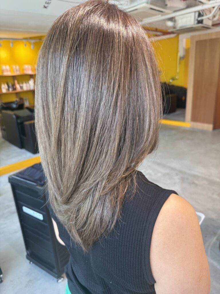 Long layered haircut with bright olive brown grey blending Plex Color at a Japanese Hair Salon Singapore, creating soft movement and natural grey coverage.
