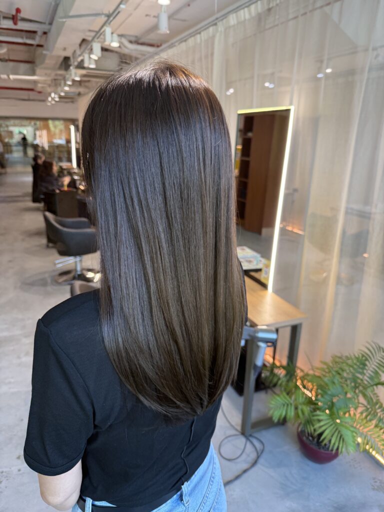 Long olive brown hair with minimal layers, glossy Plex color and smooth straight finish at a Japanese hair salon in Singapore.