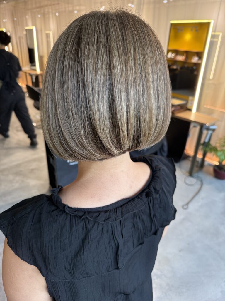 Graduated bob with beige grey coverage color, soft volume and a polished back shape at a Japanese hair salon in Singapore.