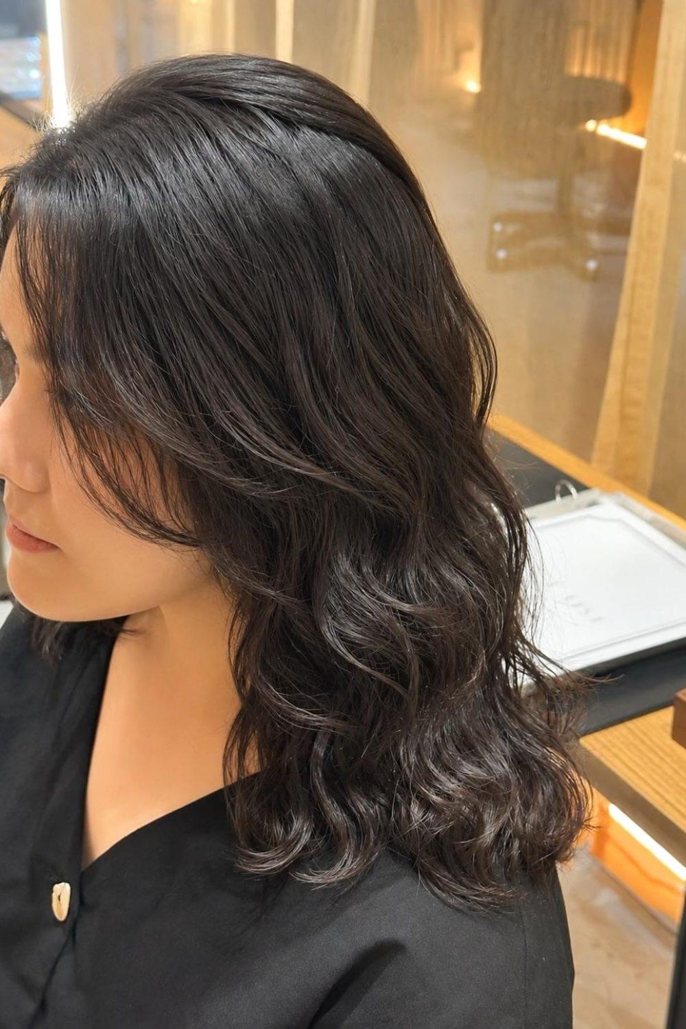 Medium black hair with digital perm, face-framing layers and soft voluminous curls at a Japanese hair salon in Singapore.