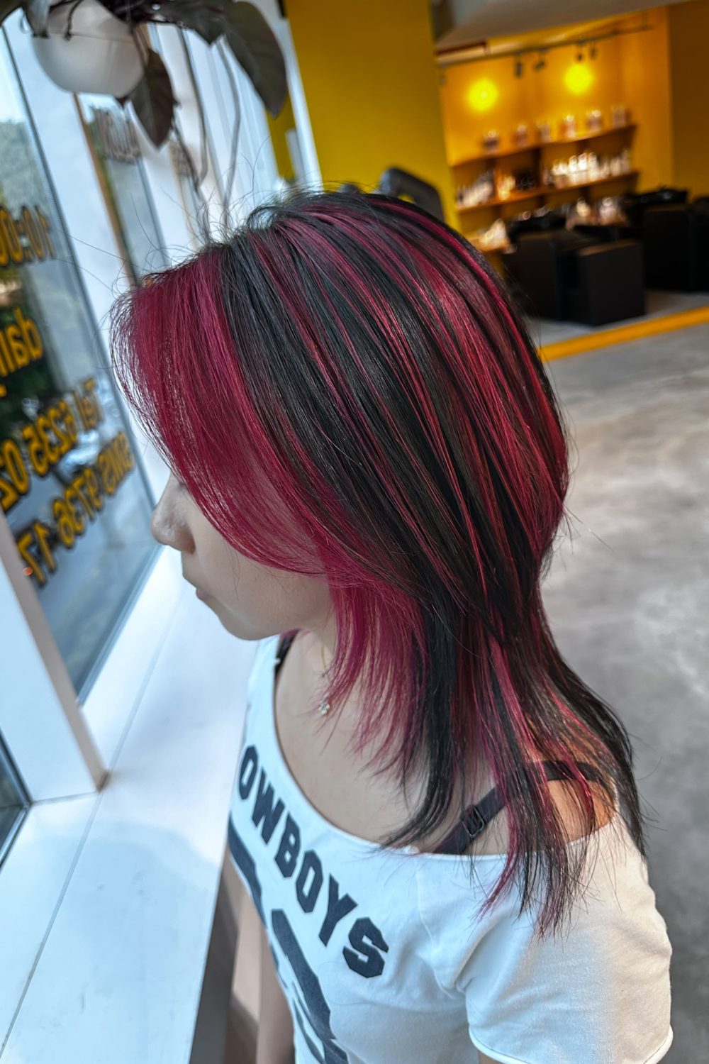 Medium layered haircut with vivid red design bleach color on a natural dark base. Japanese layer cut featuring random bleach placement, low-damage Plex bleach, and vibrant fashion hair color at Colors Japanese Hair Salon Singapore.