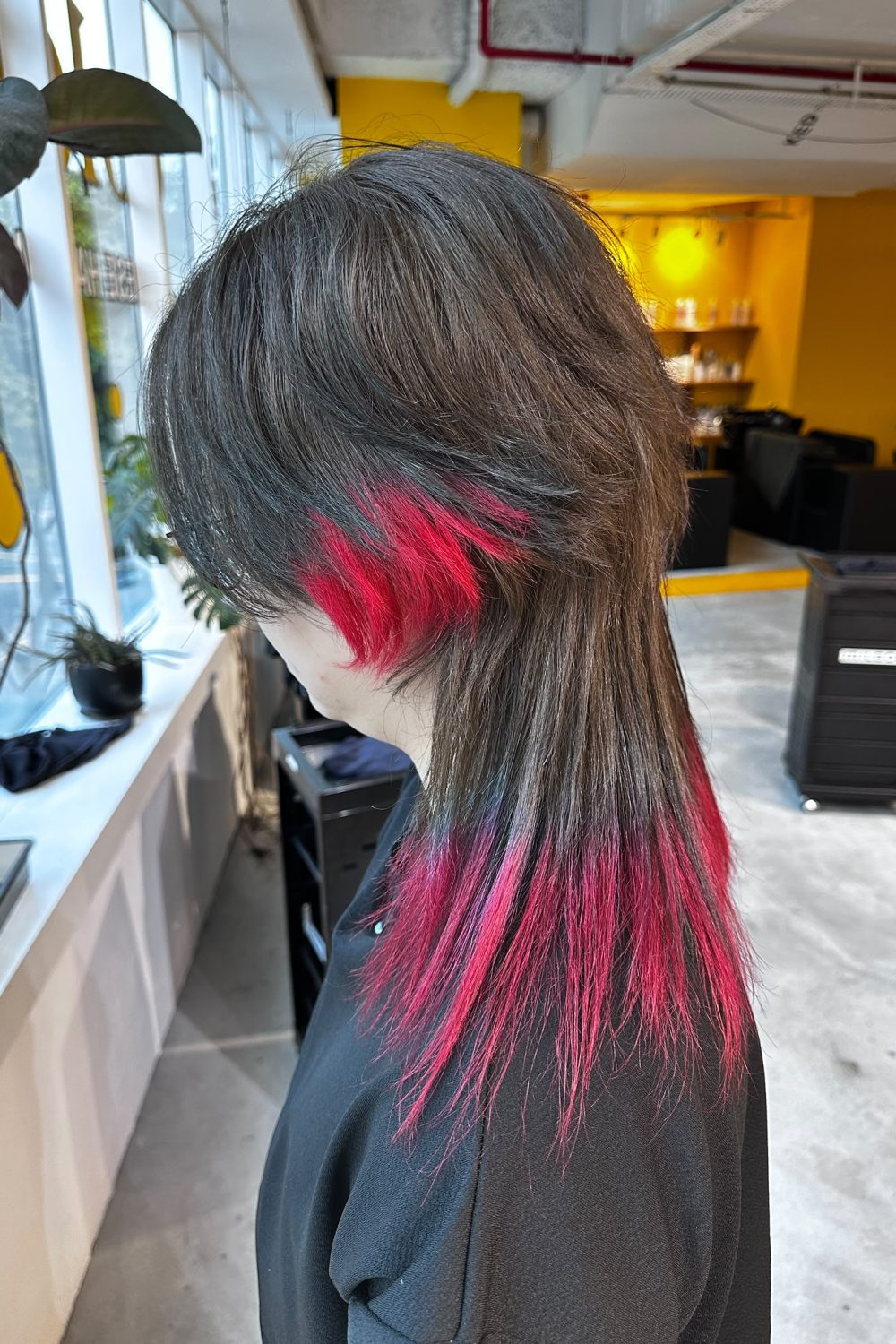 Long high-layer jellyfish cut with vivid red bleach design on the ends, featuring a disconnected layered shape and bold contrast color in Singapore