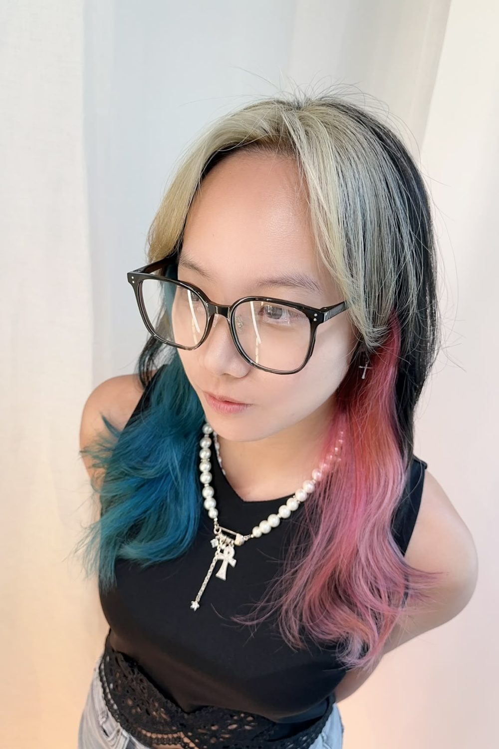 Inner color and face-framing bleach design with blonde face-framing, light pink and turquoise nape accents, and a long layered haircut in Singapore