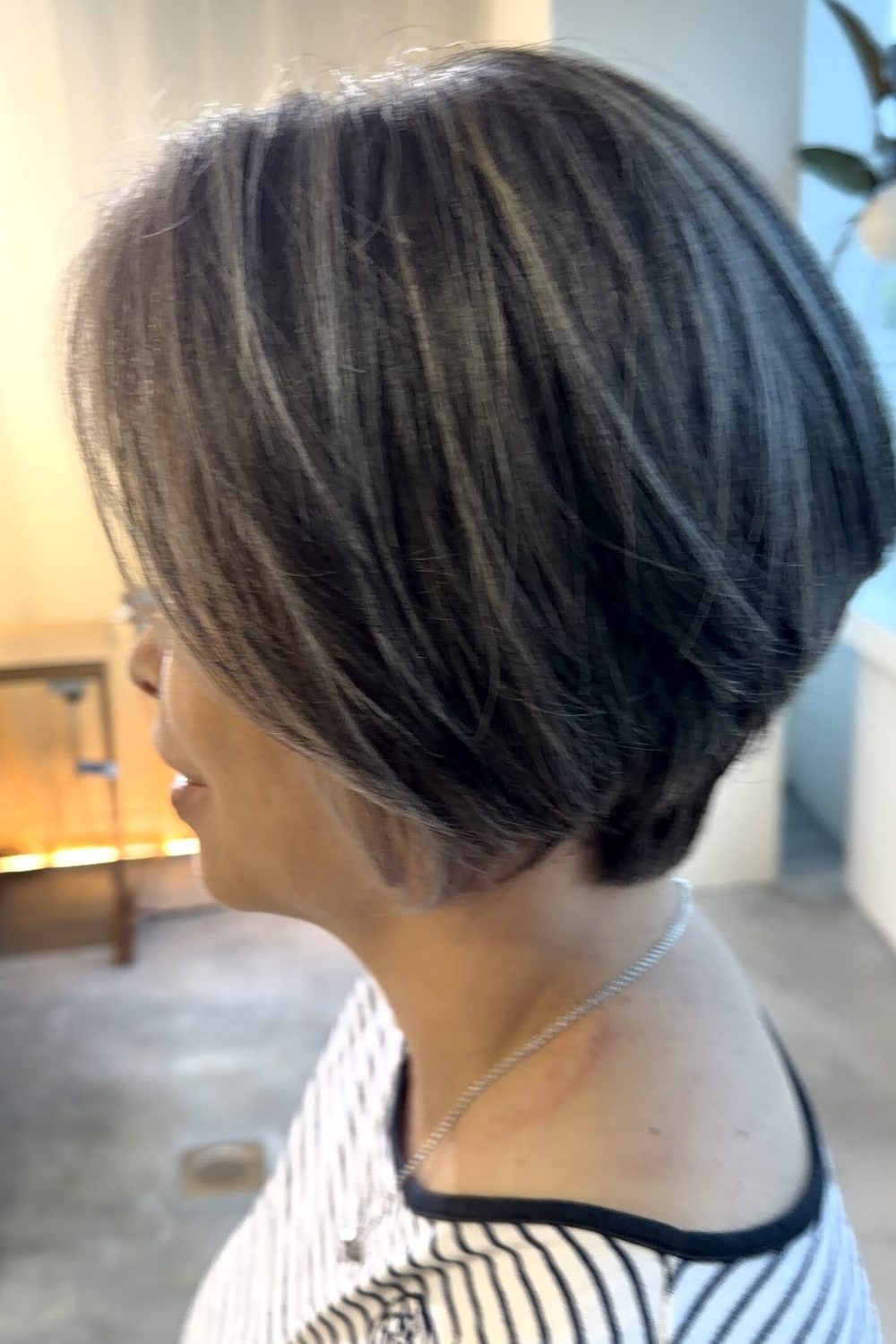 Grey blending highlights on a short graduation haircut at a Japanese Hair Salon Singapore. Natural grey hair is blended instead of fully covered using low-damage Plex Color for a soft silver finish and dimensional look.