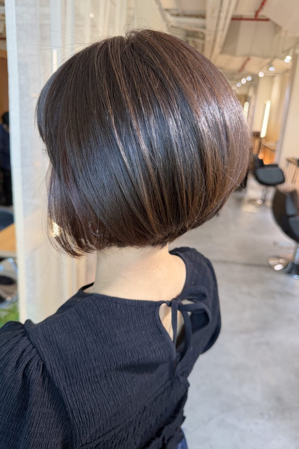 Forward-angled bob with a smooth, heavy shape and glossy cool brown Plex color, created for better manageability and shine at a Japanese hair salon in Singapore.