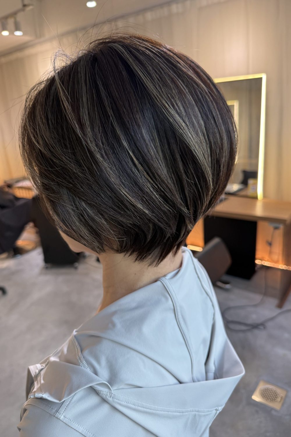 Grey blending highlights on a short bob haircut in Singapore with ash-toned bleach highlights, white hair blending, low-maintenance hair color, and Japanese haircut by Colors Japanese Hair Salon Singapore