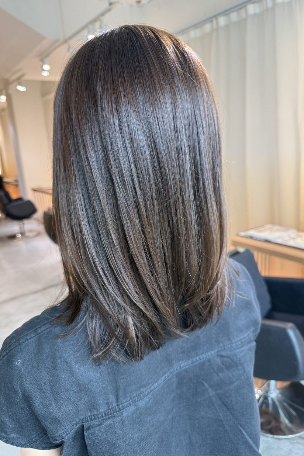Medium low layer haircut with olive hair color in Singapore designed to reduce red undertones for thick hair at a Japanese hair salon.