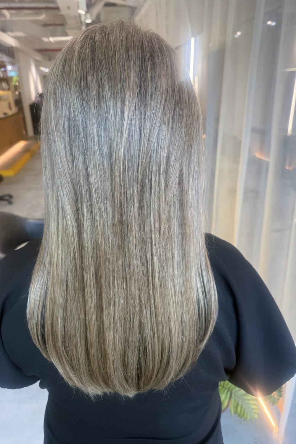 Fine blonde highlights on long layered hair created with low-damage Plex bleach and toner at a Japanese Hair Salon Singapore. This long hair highlight design adds brightness, movement, and dimension while providing a lower-maintenance alternative to full bleach.