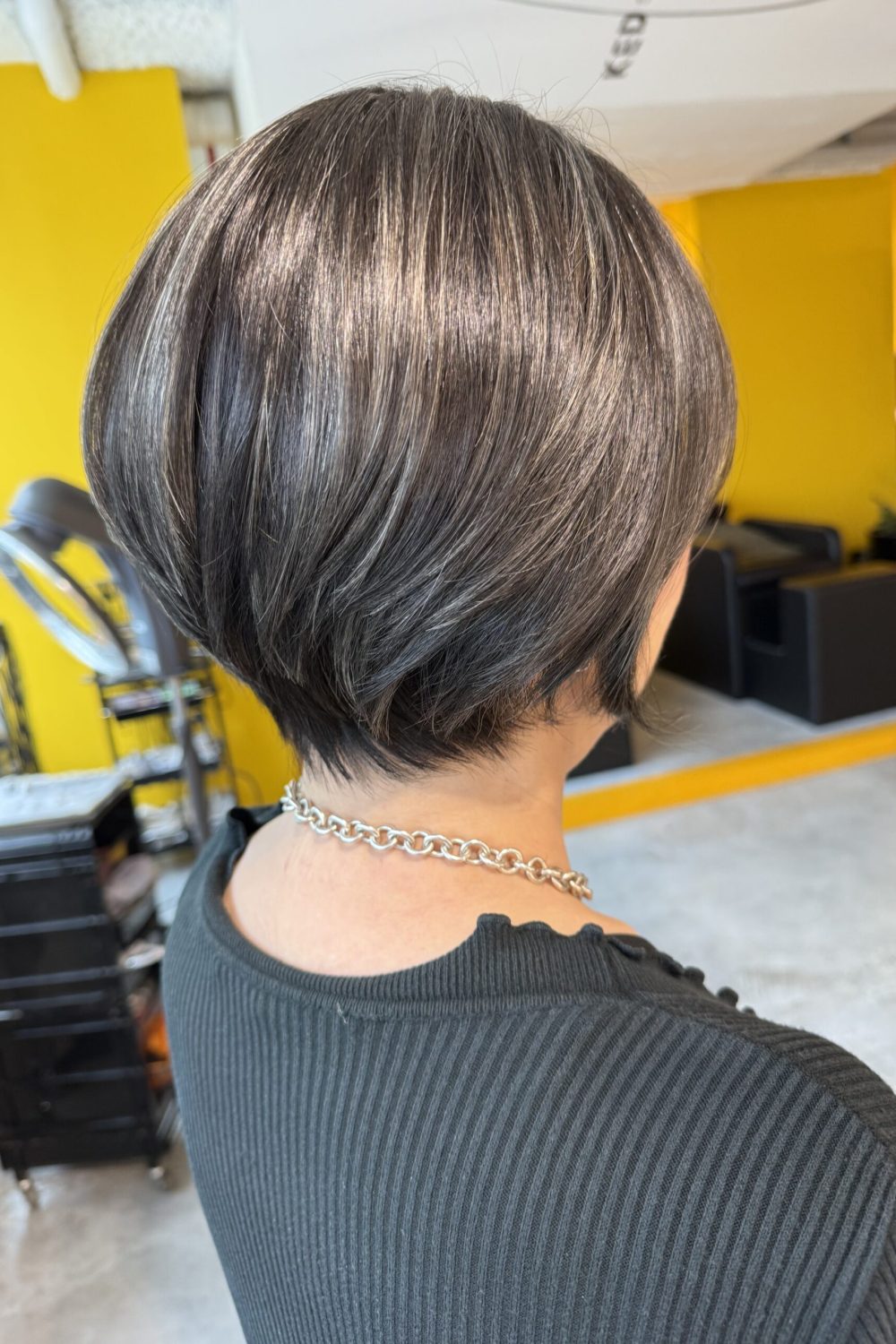 Grey blending short hairstyle with dark silver base and natural grey coverage at Japanese Hair Salon Singapore. Low-damage highlights create a soft silver blend for a modern, elegant short haircut.