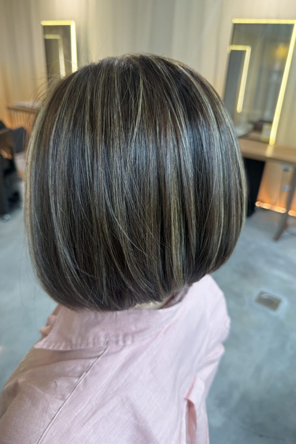 Grey blending highlights with ash beige tones on an angled bob at a Japanese Hair Salon Singapore. Low-damage Plex bleach, scalp cleansing spa, and HOYU treatment create natural grey blending with smooth, glossy hair.