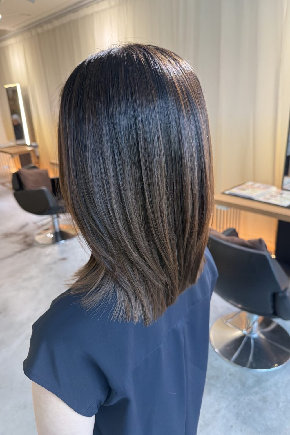 Natural bleach-free light brown highlights with a medium low layer haircut at a Japanese Hair Salon Singapore for soft dimension and easy maintenance.