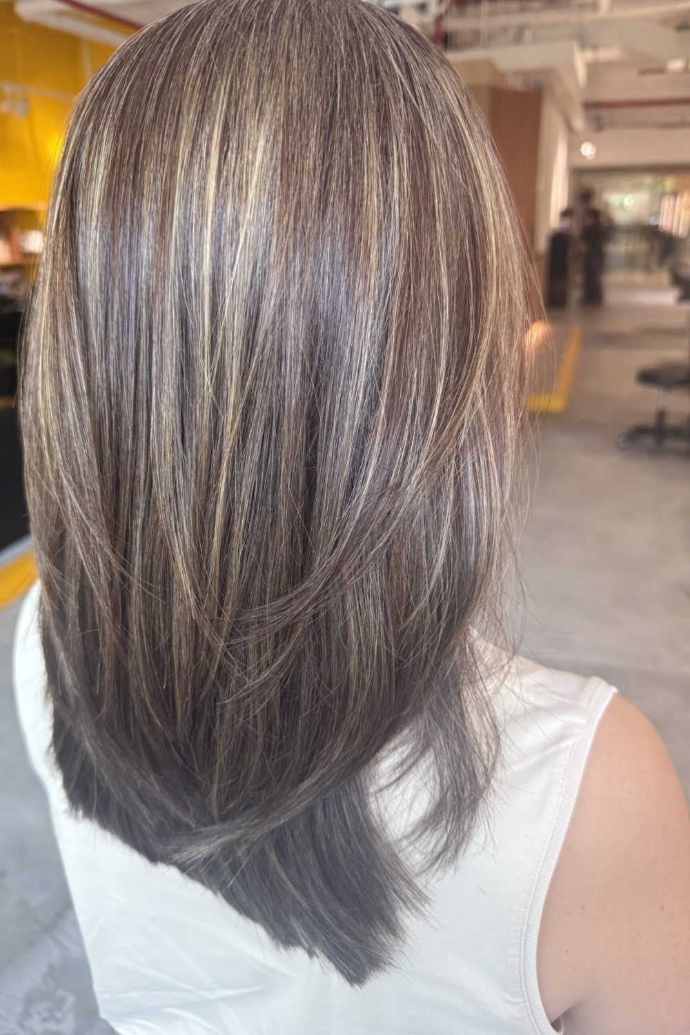 Medium low-layer haircut with beige ash grey blending highlights, smooth straight texture and natural grey blending at a Japanese hair salon in Singapore.