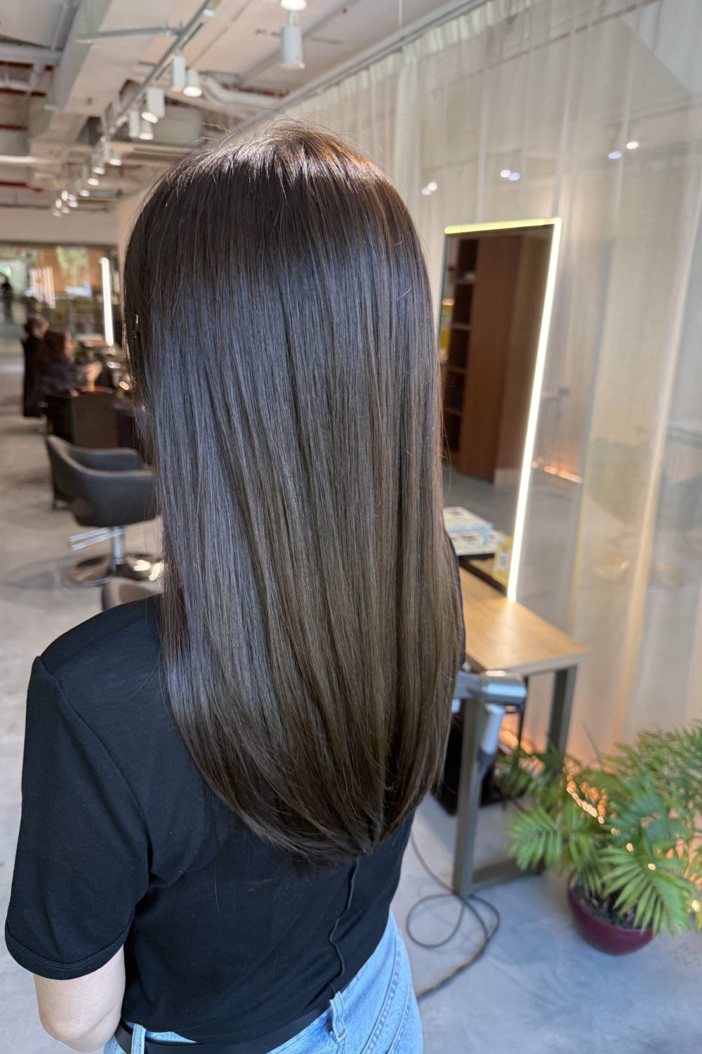 Long olive brown hair with minimal layers, glossy Plex color and smooth straight finish at a Japanese hair salon in Singapore.