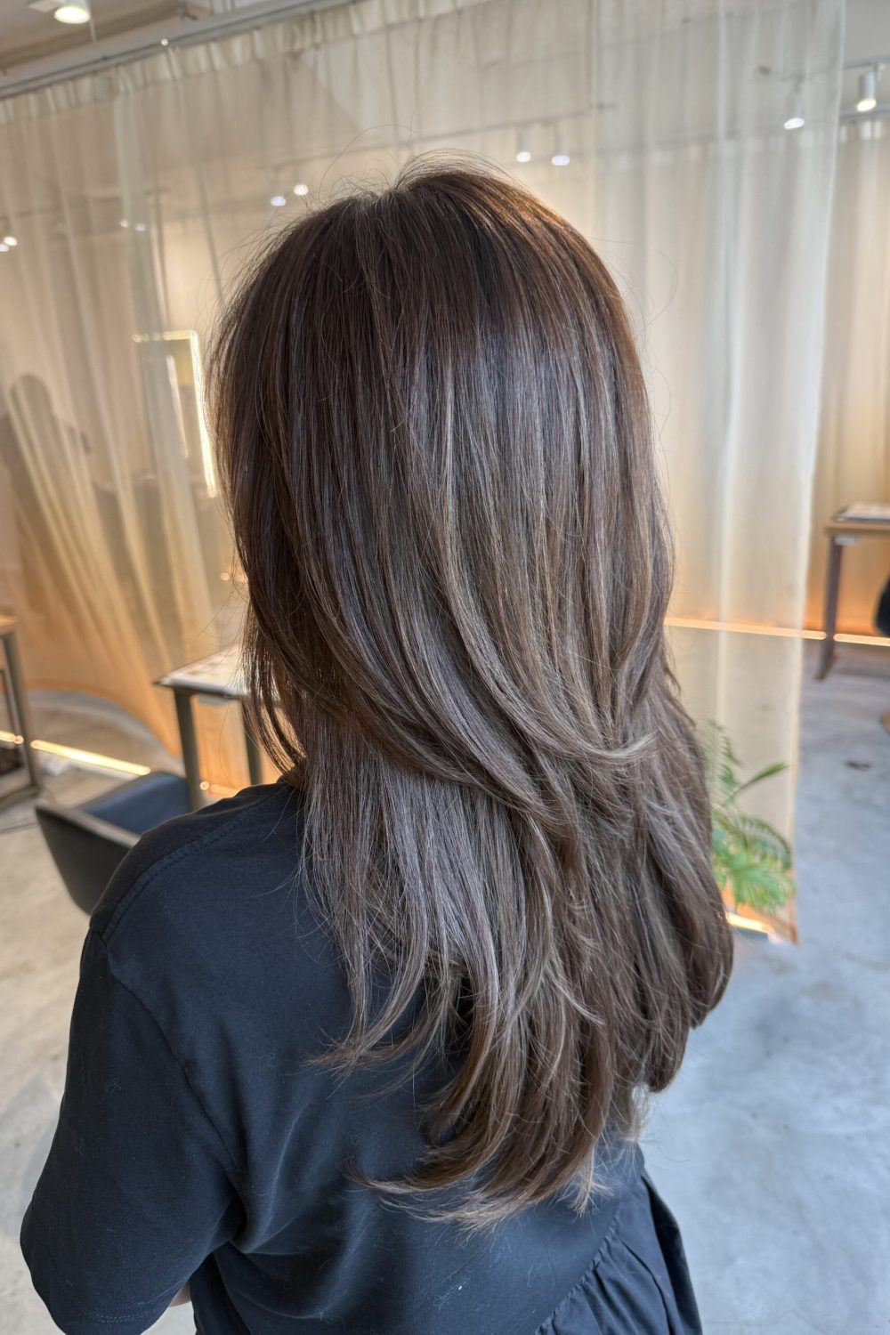 Long high-layer hair with ash brown grey coverage, soft volume and movement, created with Plex color at a Japanese hair salon in Singapore.