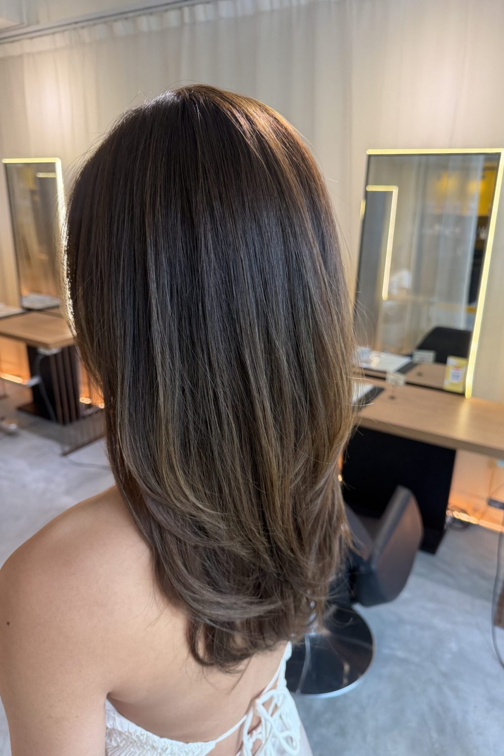 Long layered haircut with face framing layers and monotone hair color in Singapore for softer movement and brighter hair without bleach at a Japanese hair salon.