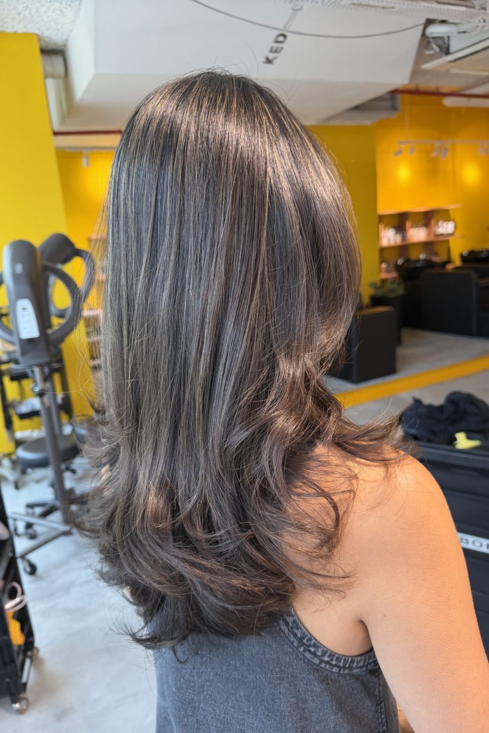 Grey Blending Highlights on a long layered haircut in Singapore using fine bleach highlights and toner without coloring the natural base. Low-damage Plex bleach creates natural grey blending, soft movement, volume, and easy maintenance at a Japanese Hair Salon Singapore.