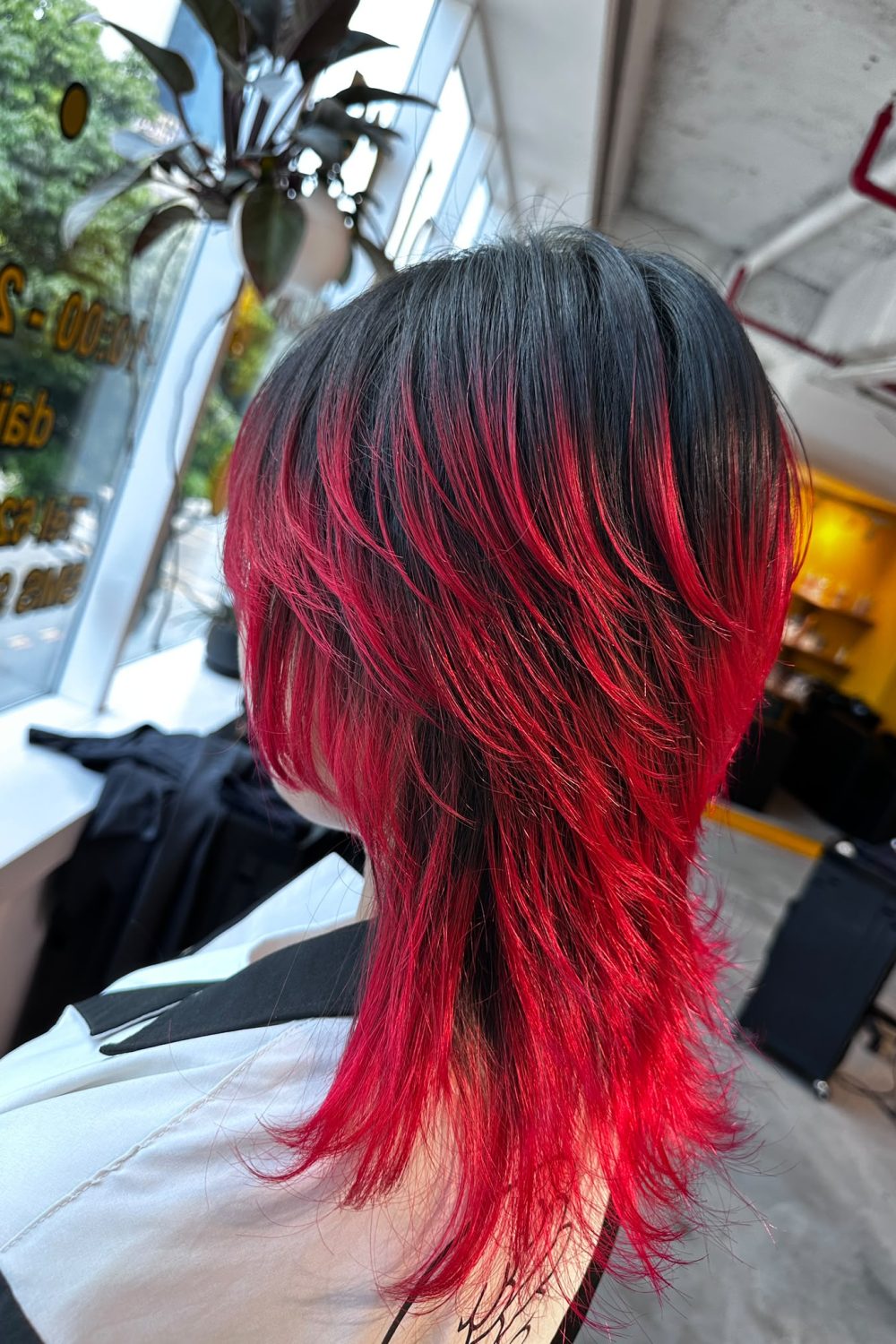 Long high-layer wolf cut with red dip color bleach design on the ends and natural roots in Singapore